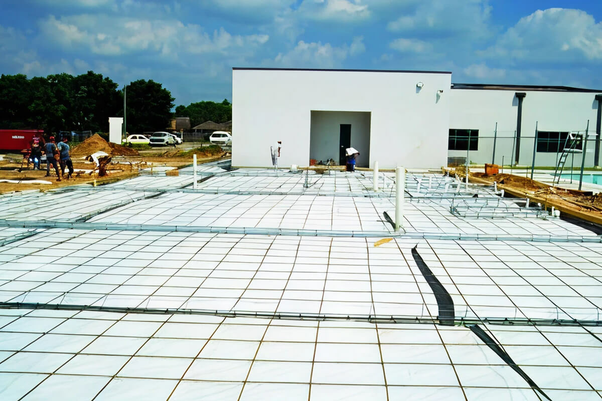 Griffolyn reinforced polyethylene vapor retarder installed over rebar grid on commercial construction site prior to concrete pour